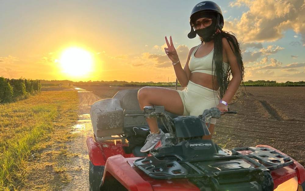 Woman riding an ATV at sunset